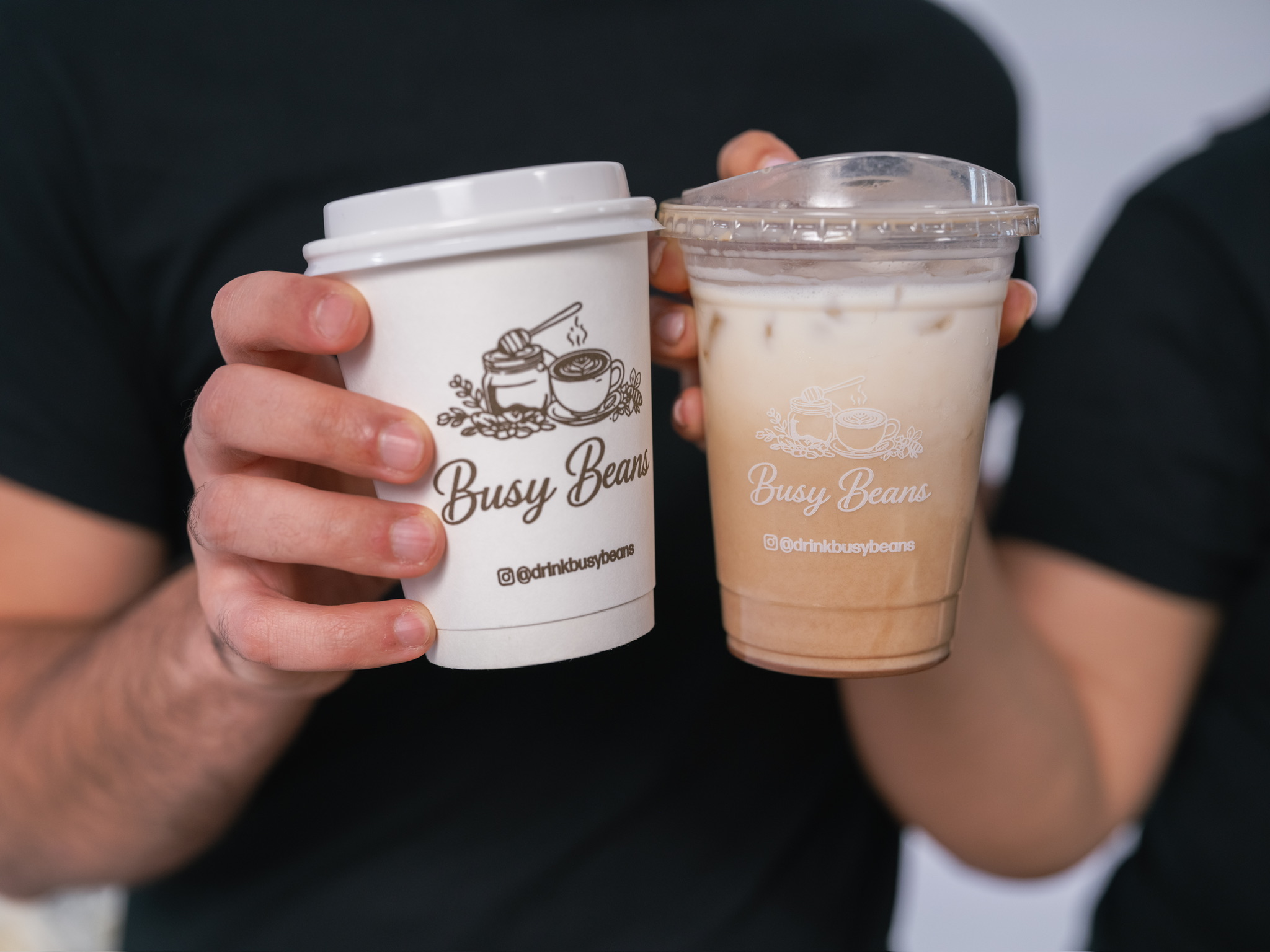 Guest holding a Busy Beans branded cup at an event