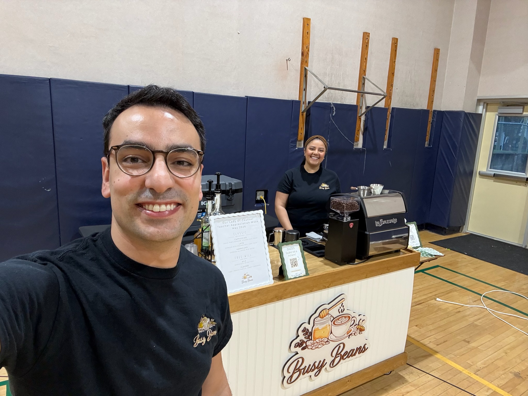 Mark and Kristina behind the cart in a school gym for teacher-appreciation week