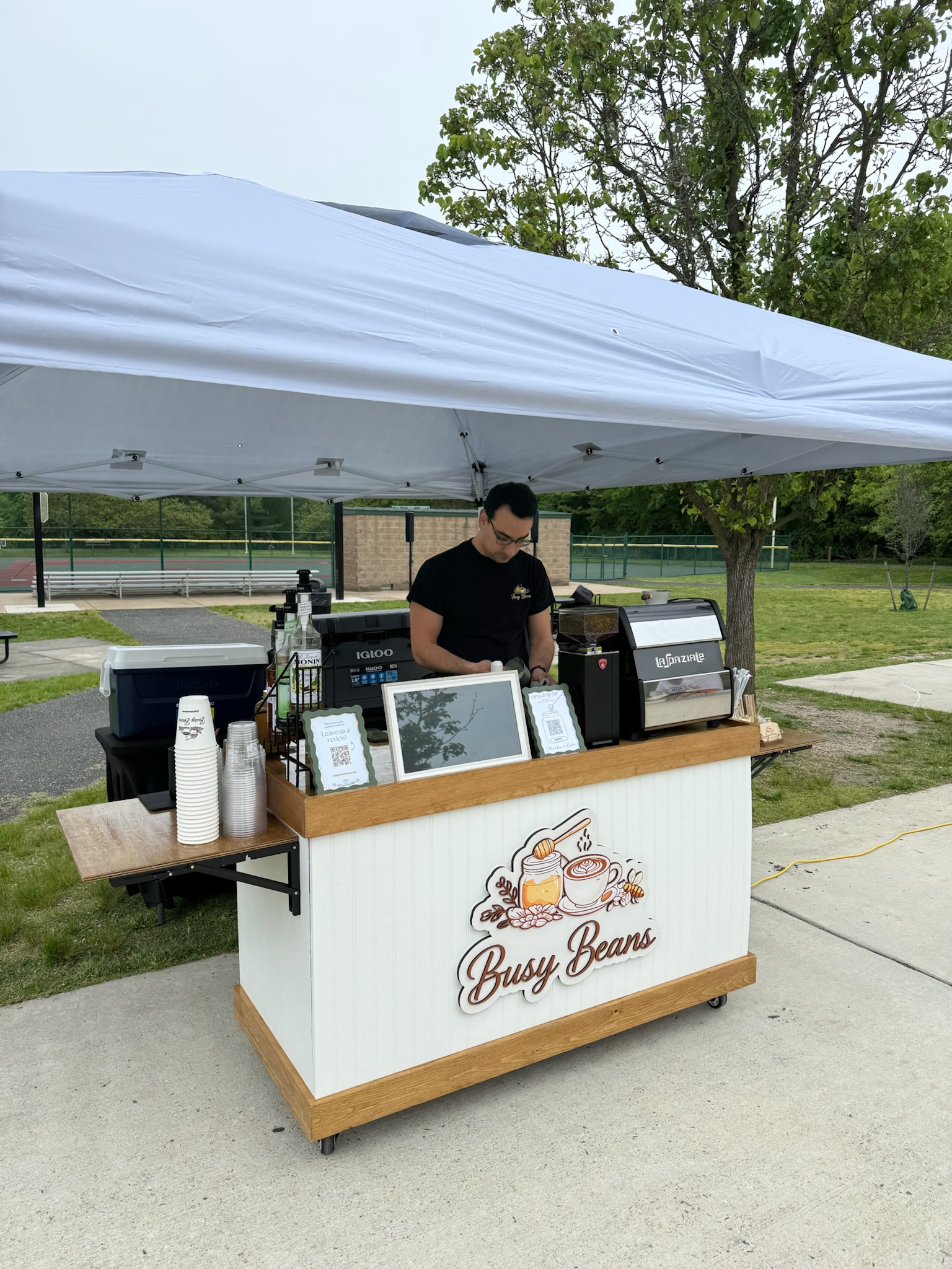 Busy Beans cart under a tent at an outdoor park, serving a charity 5K run