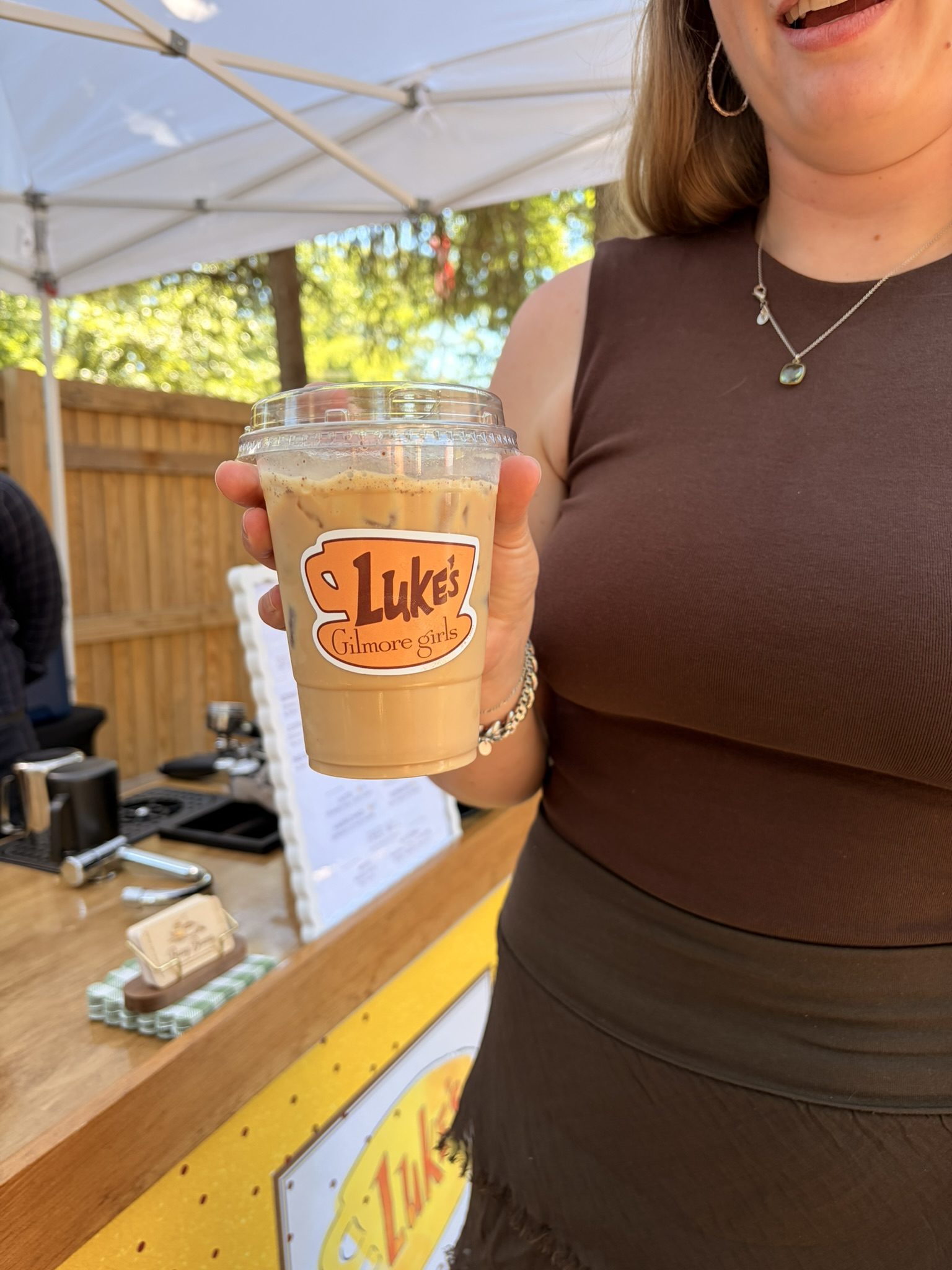 Close-up of a custom-branded iced coffee cup at a themed Busy Beans event