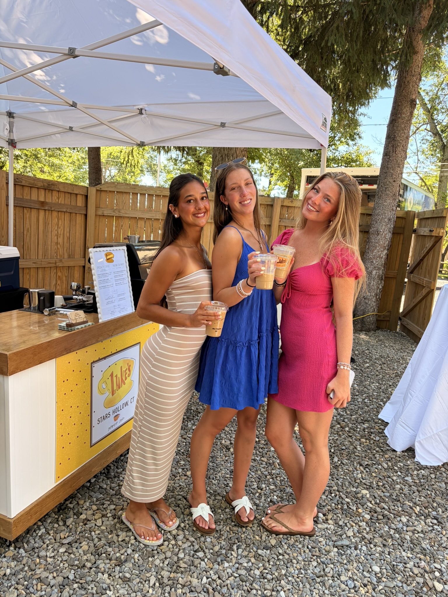 Three guests toasting with iced coffees at a custom-themed Busy Beans event