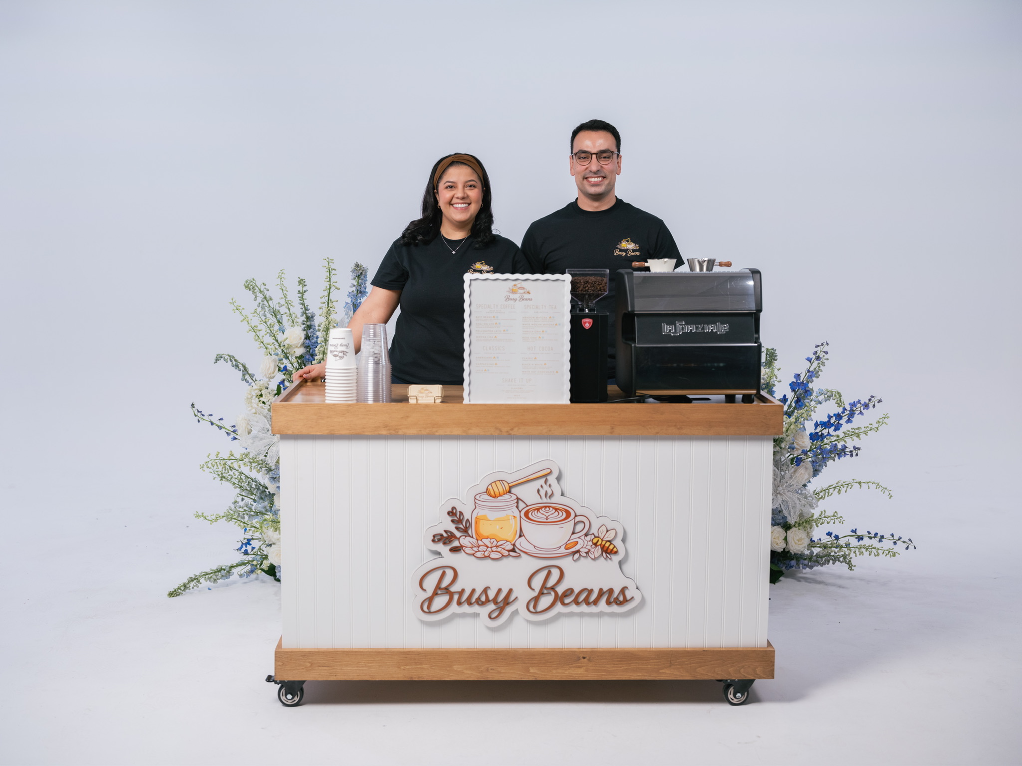 Mark and Kristina, the Busy Beans husband and wife team, smiling behind the cart